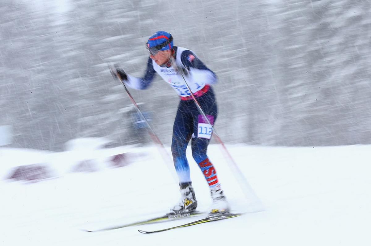 a man uses skies and poles to get across the snow