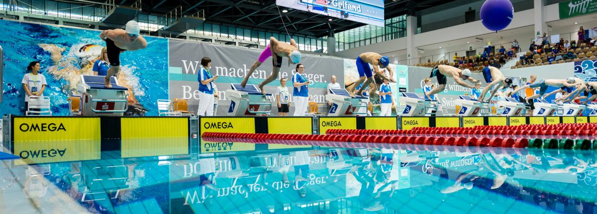 a group of men dive into a pool