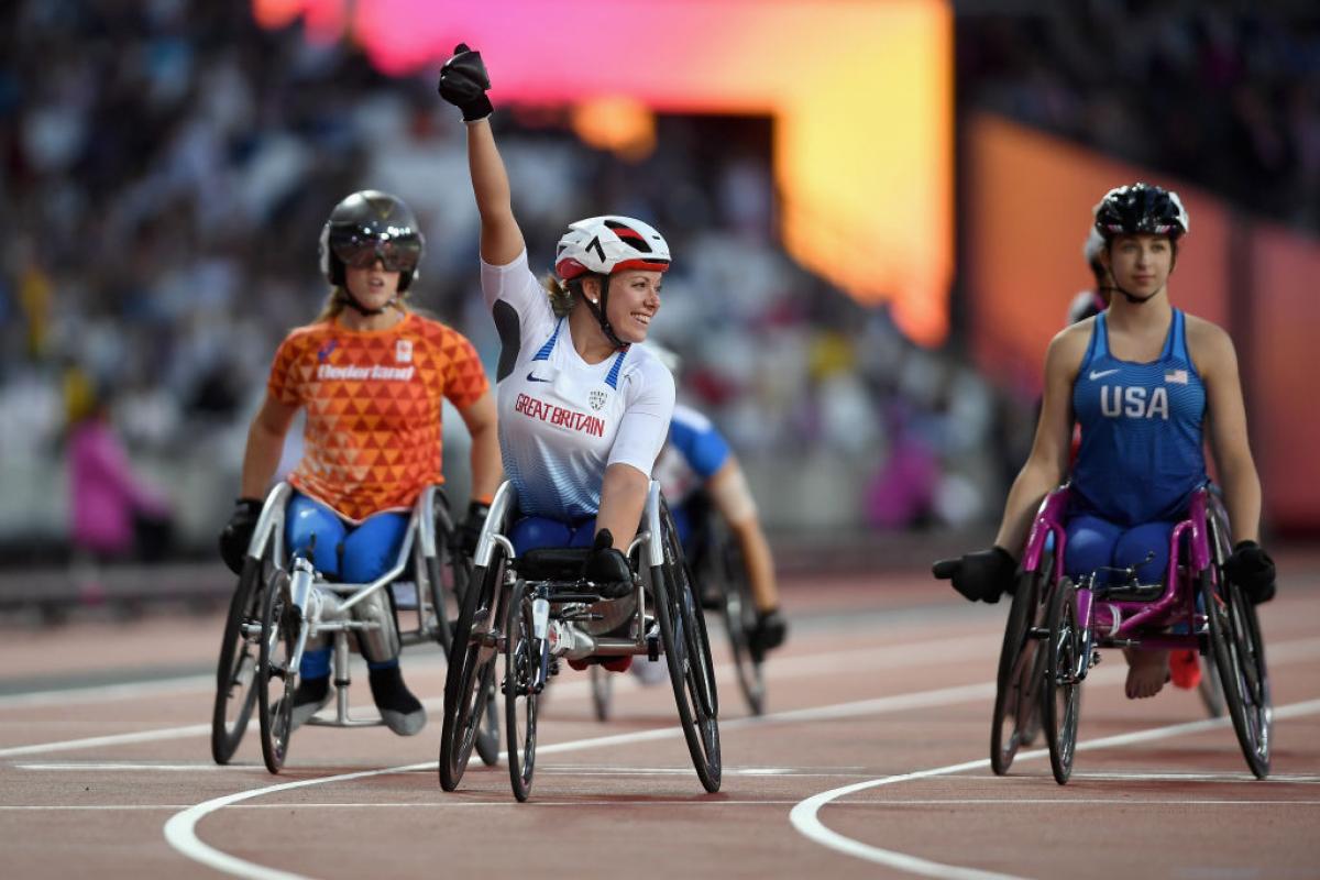 a wheelchair racer celebrates winning a race