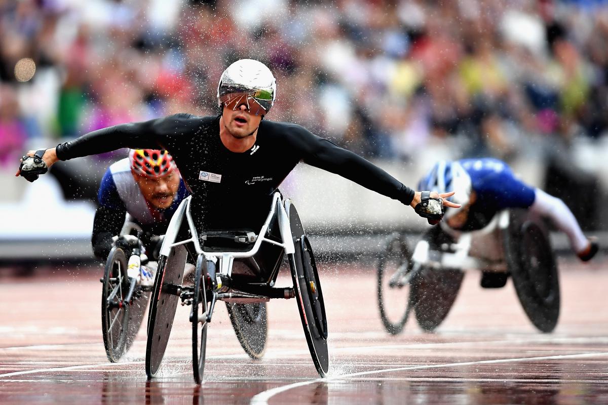 The Swiss Silver Bullet celebrates in the rain after winning the men's 5,000m T54 at London 2017.