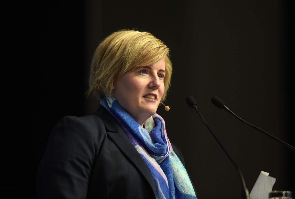 A woman speaks at a podium