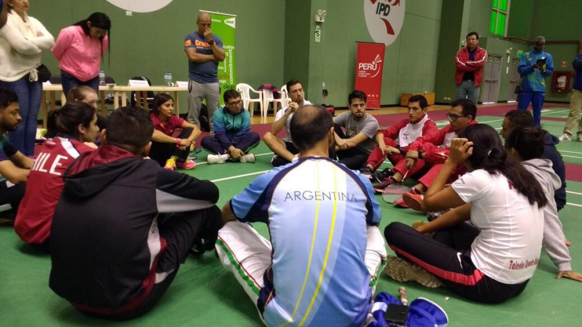 a group of para athletes sit having a group discussion