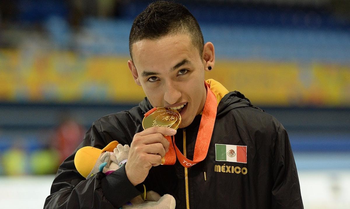 a man bites his medal on the podium