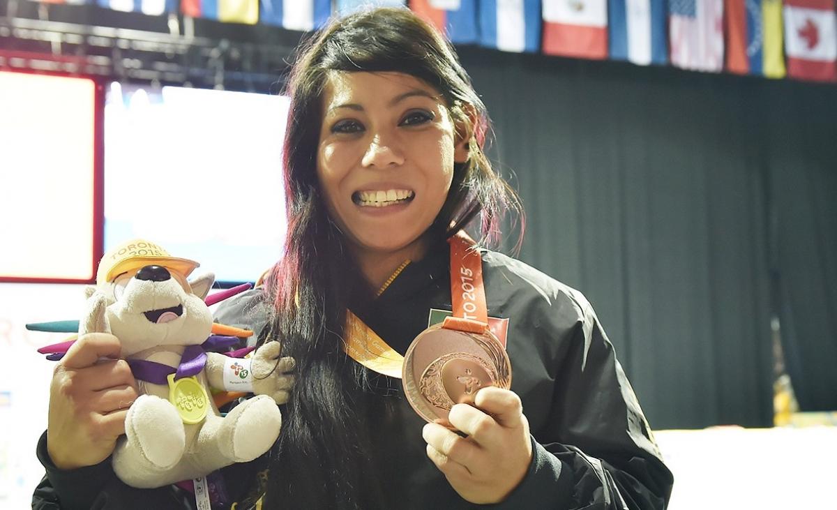 a Para athlete holds her medal and smiles