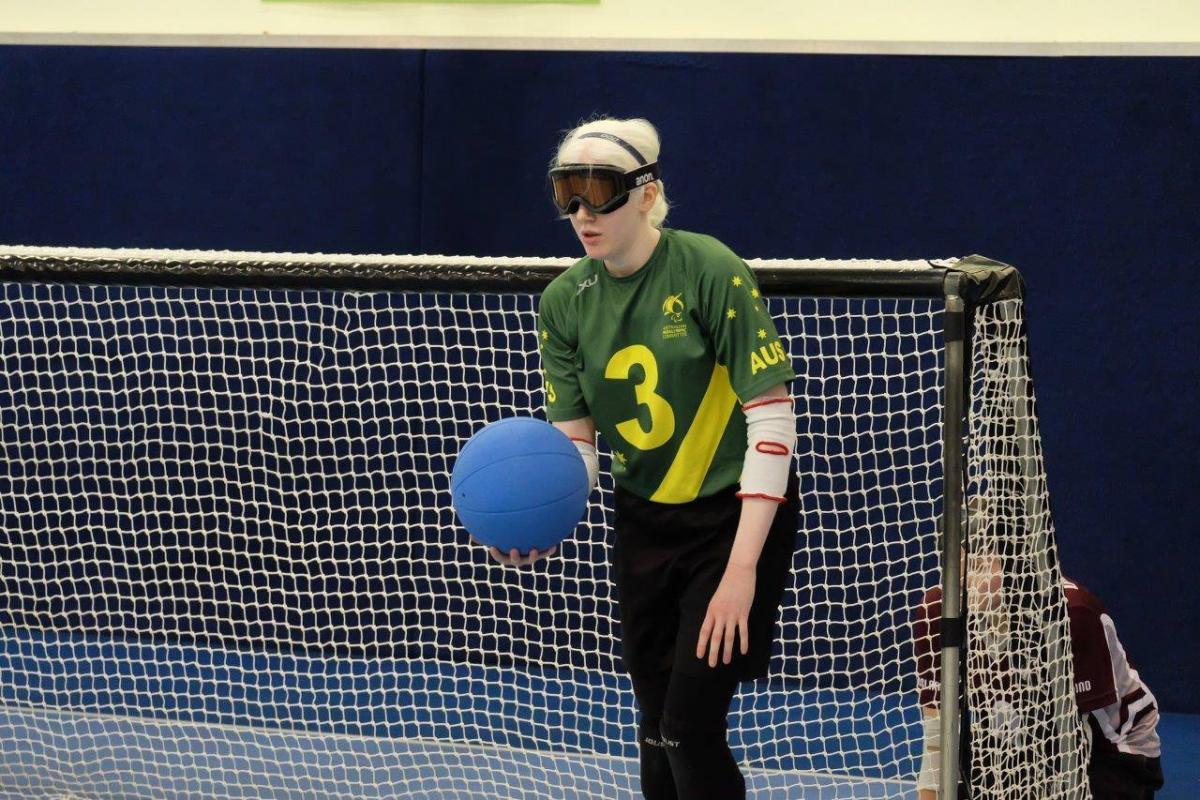 A female goalball player holds the ball