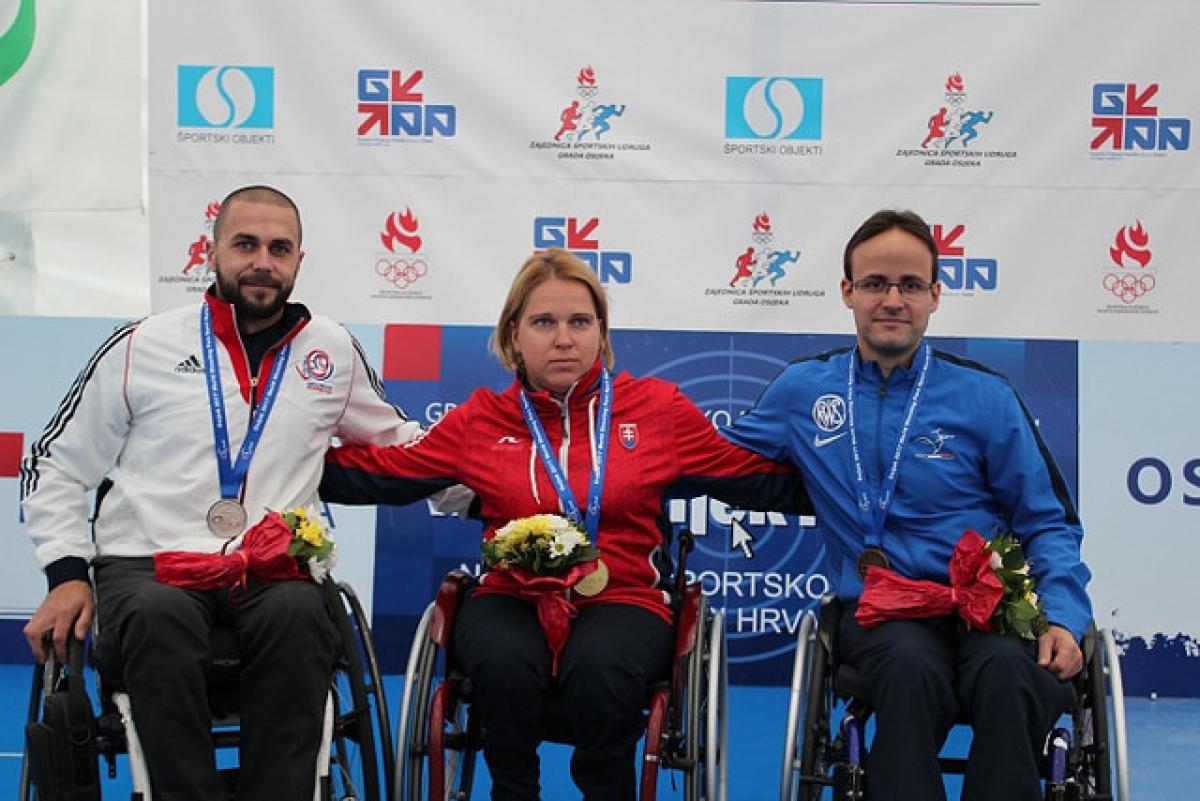 a group of three wheelchair athletes on the podium