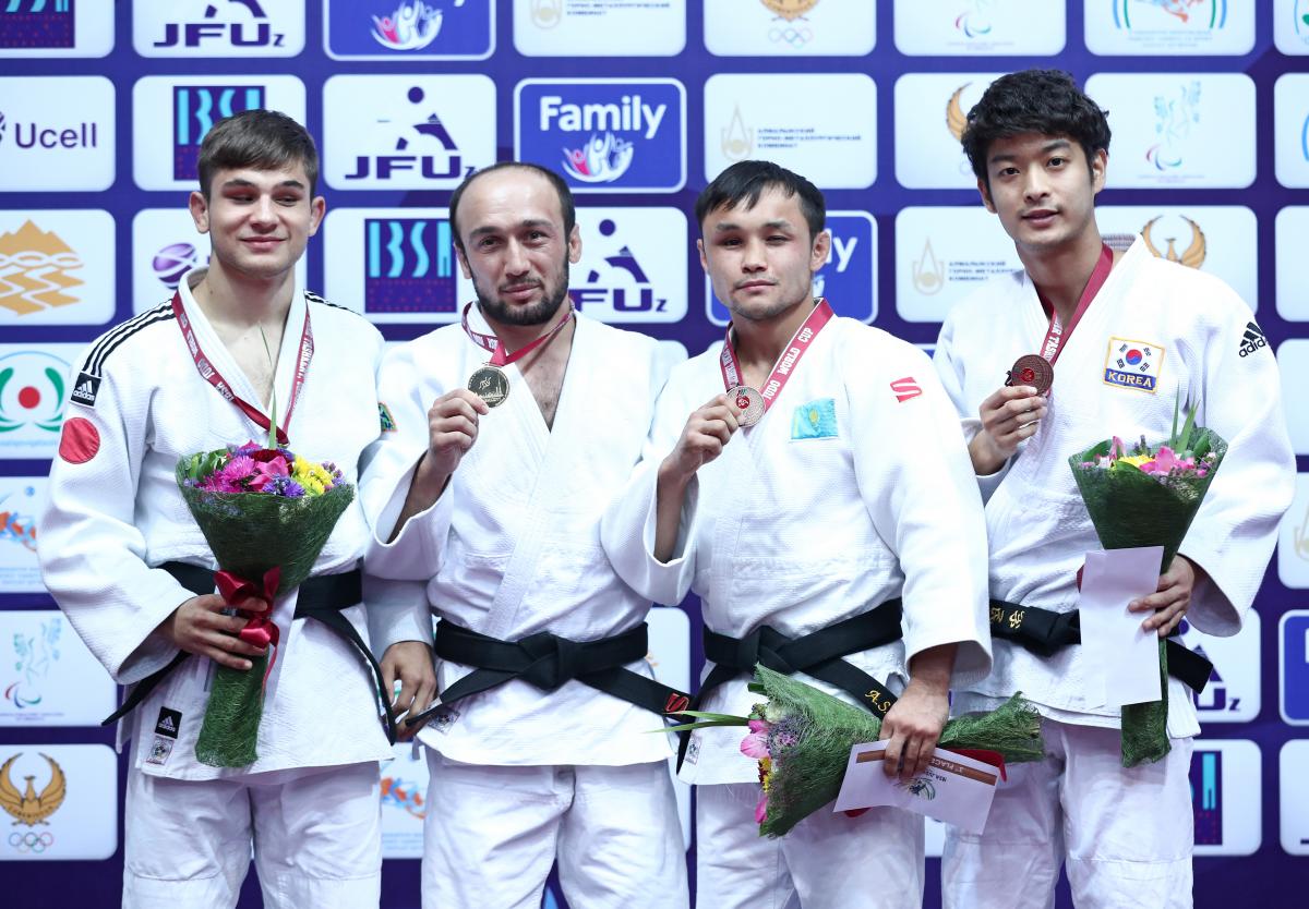 four Para judokas stand on the podium with their medals 