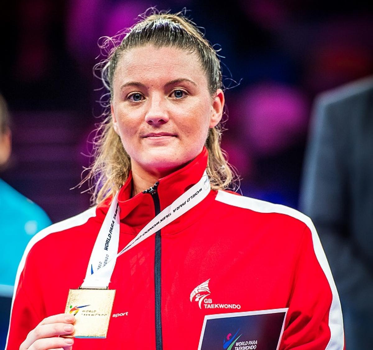 a female Para athlete with her gold medal