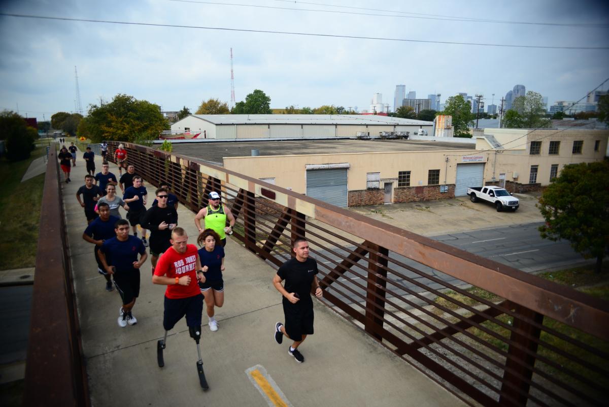 Double amputee running with group of people running behind him