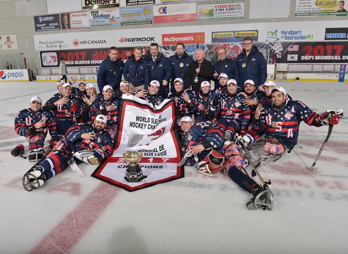 A group of Para ice hockey players pose with their trophy on the ice