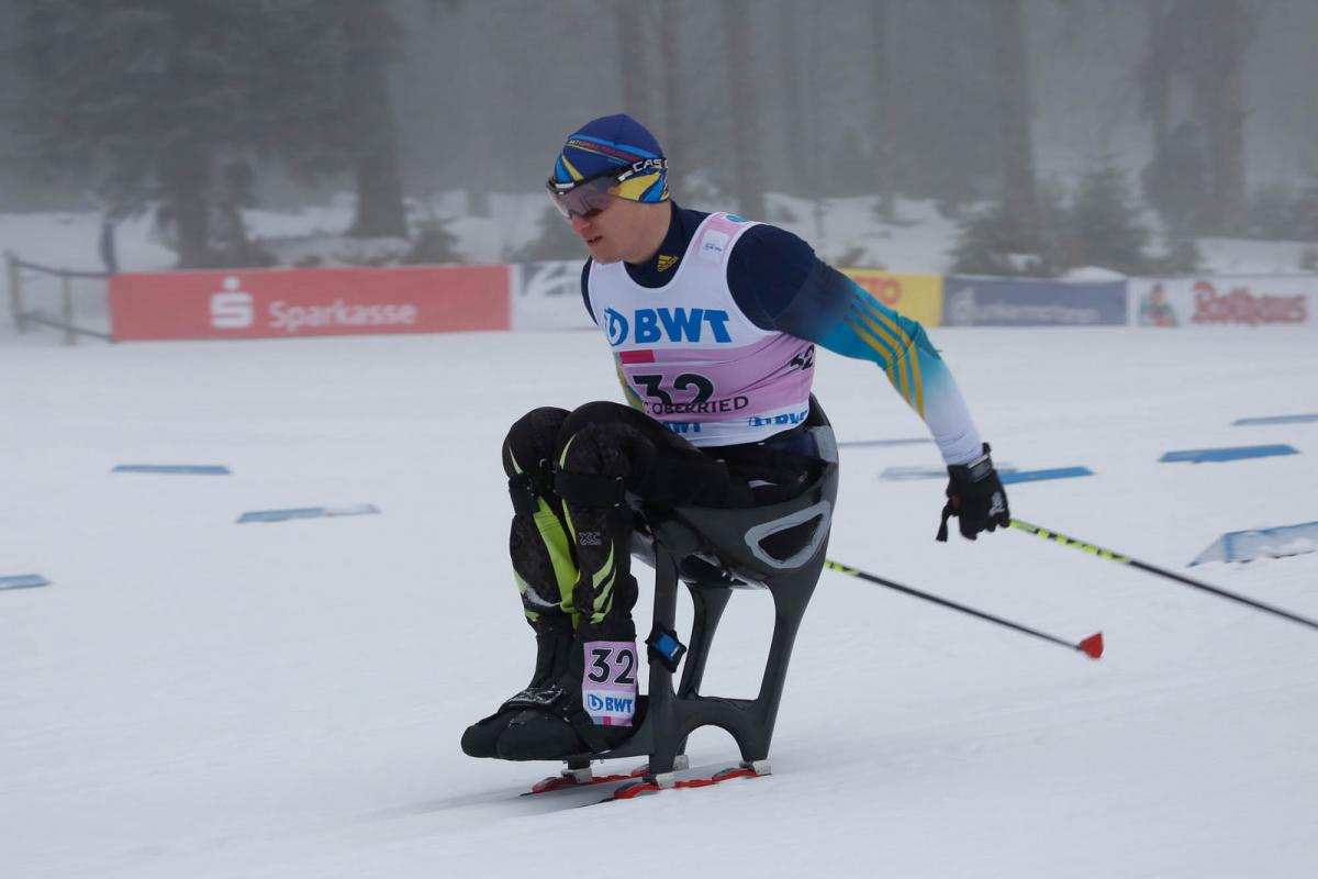 a male sit skier ploughs through the snow