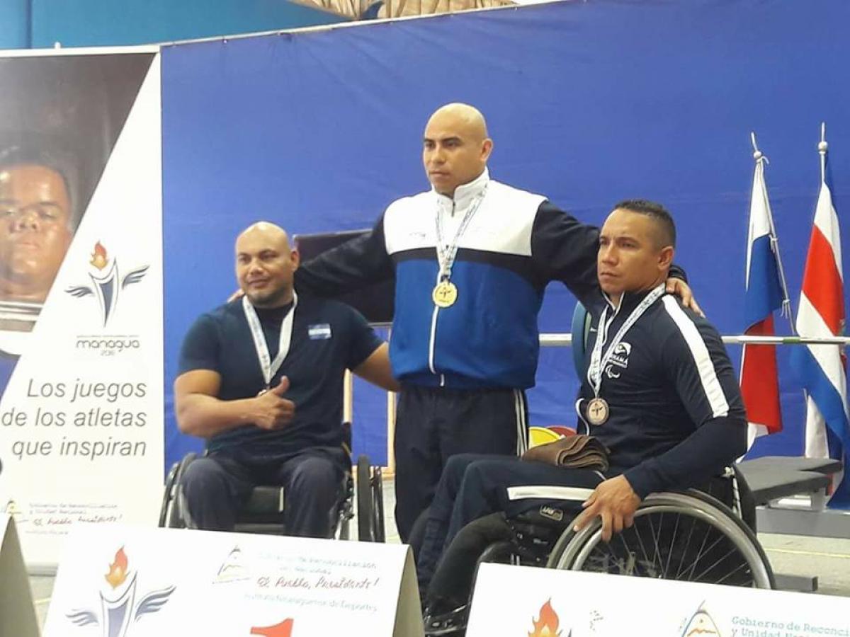 three male powerlifters ona podium