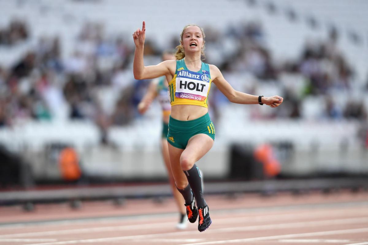 a female Para sprinter crosses the line to win the race