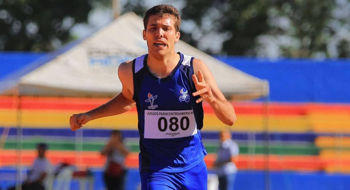 a male Para athlete crosses the finish line