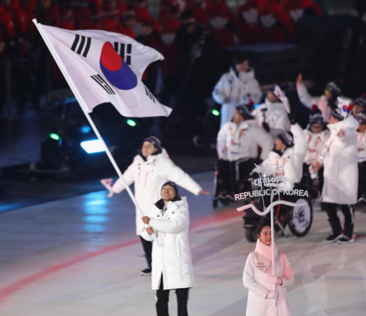 an athlete holds a South Korean flag