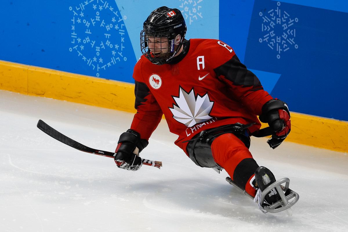 a male Para ice hockey player celebrates a goal