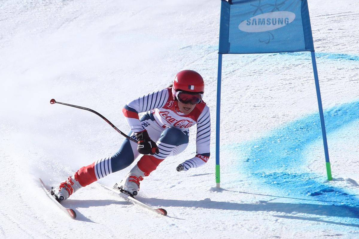 a female Para skier rounds a gate