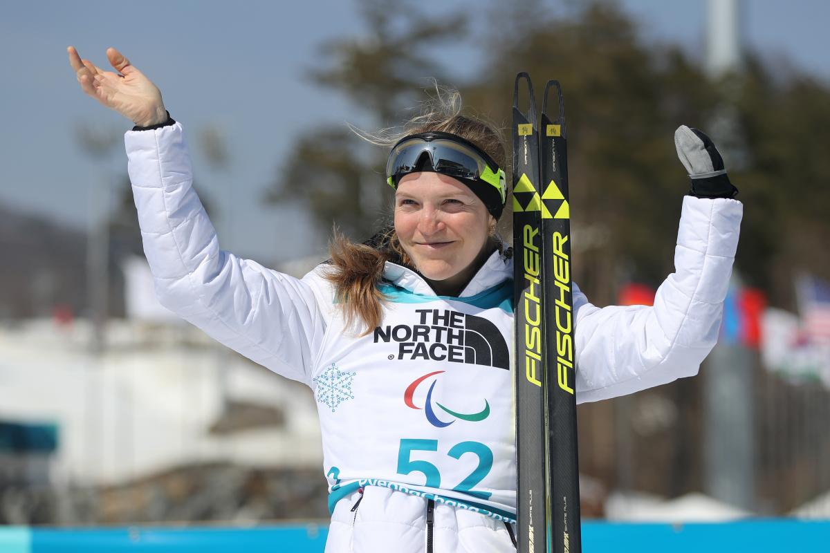 a female Para biathlete celebrates on the podium