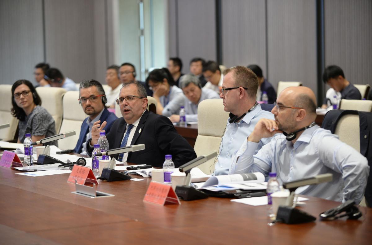 a group of men speaking at a table