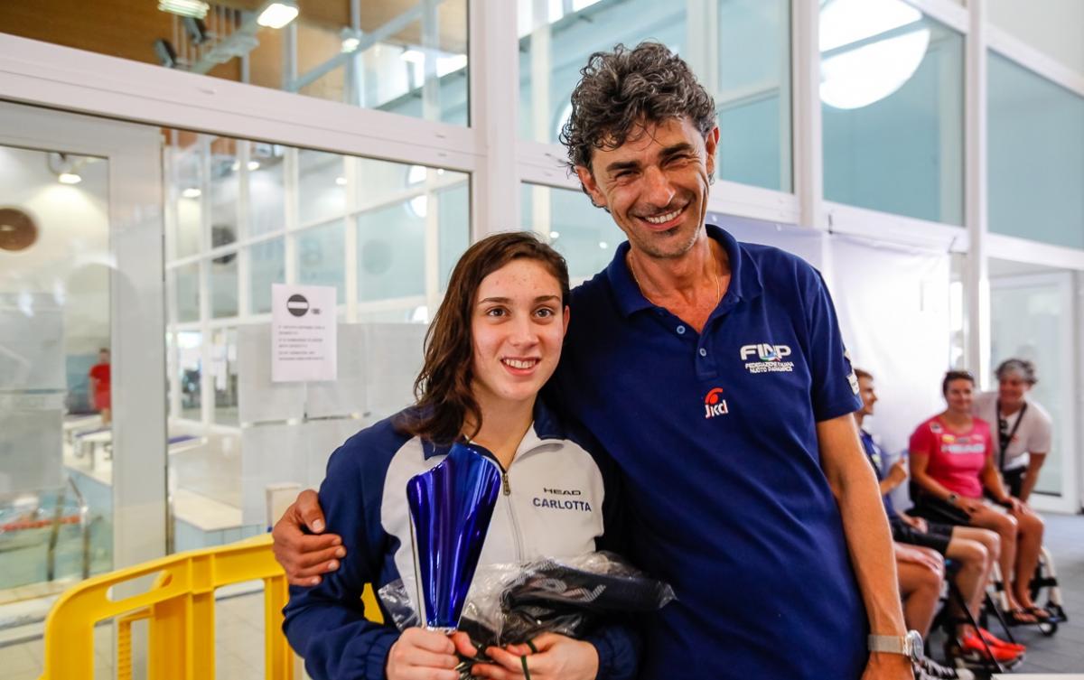 a female Para swimmer is hugged by her coach