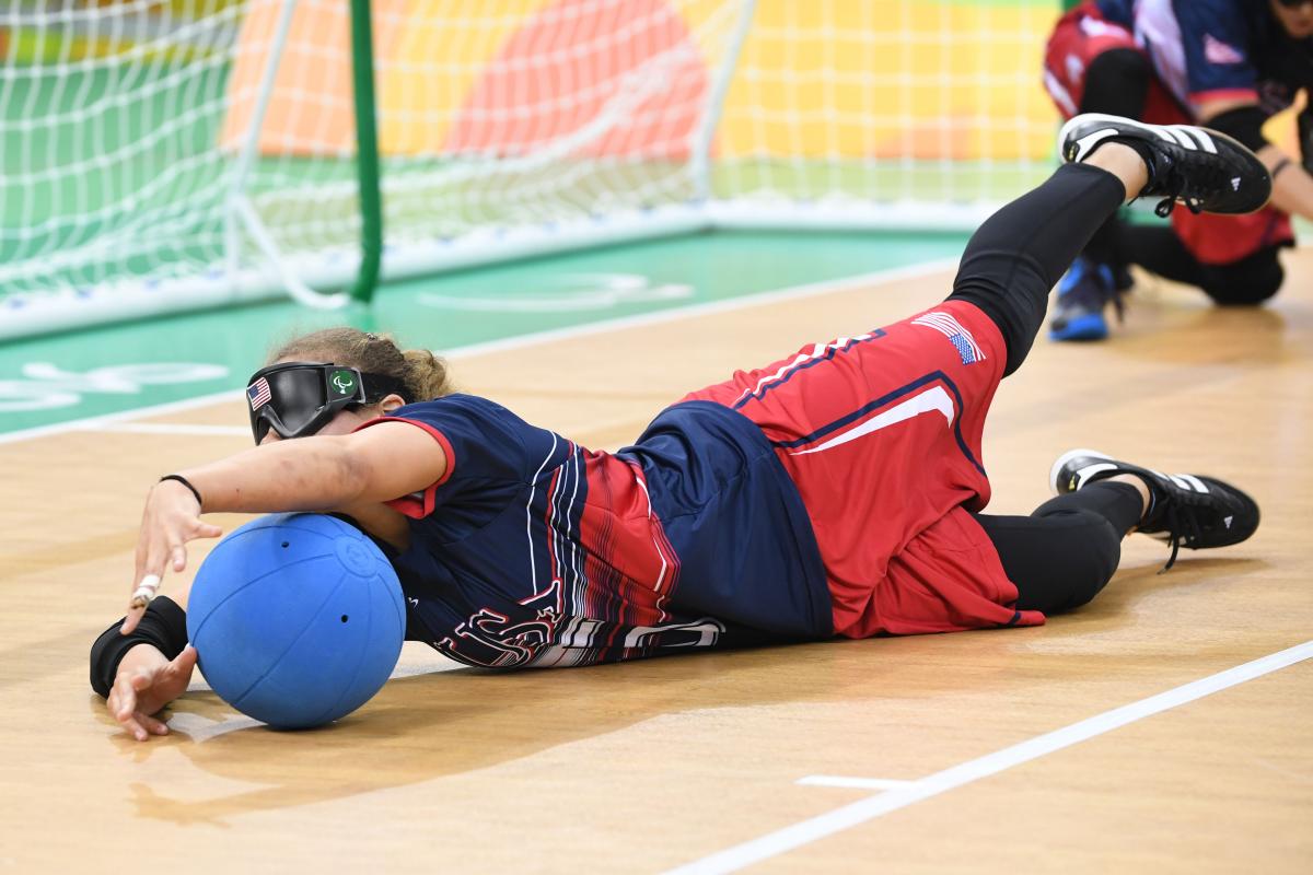 a female goalball player saves a shot