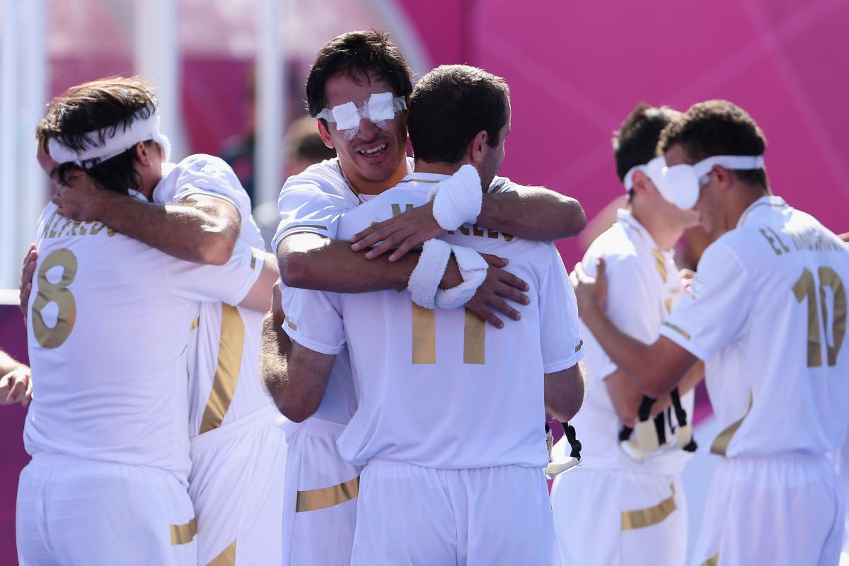 a group of blind footballers hugging eachother