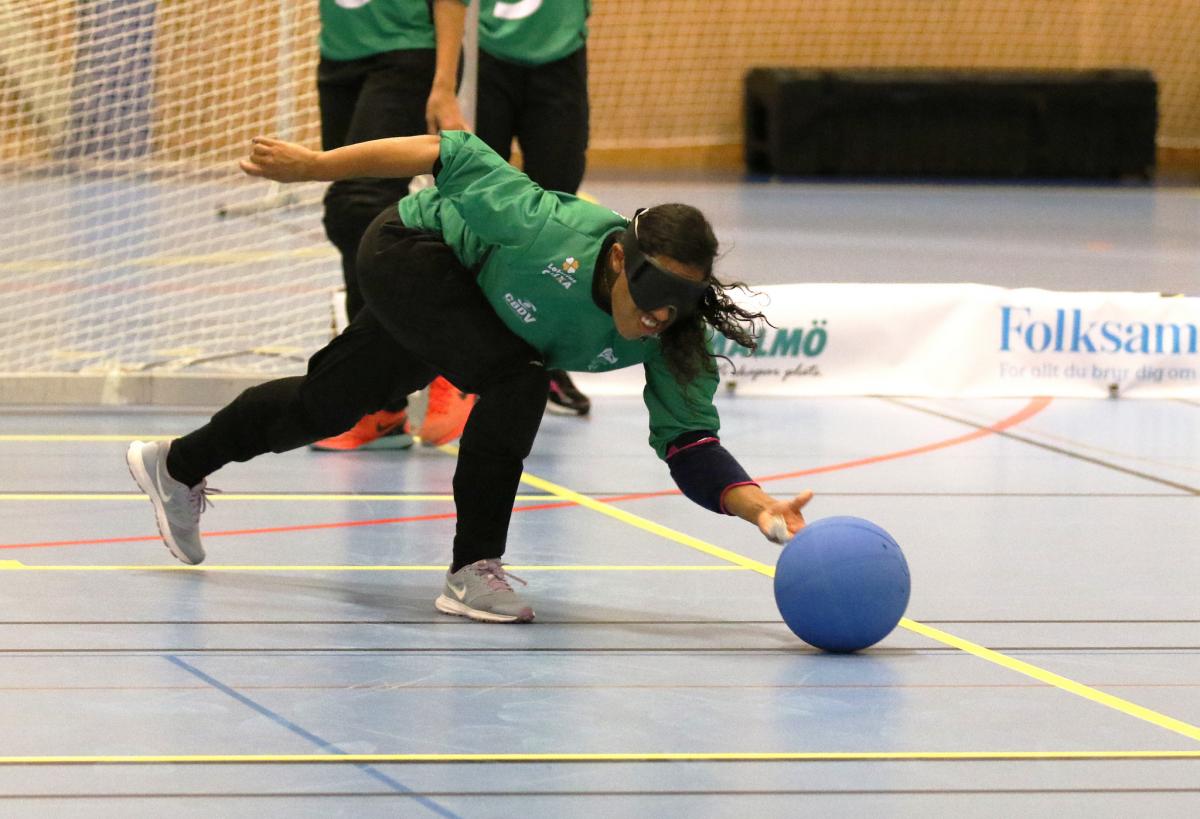 a female goalball player throws the ball