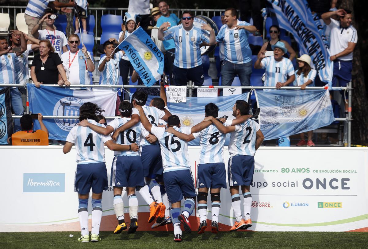 a group of blind footballers celebrating with the crowd