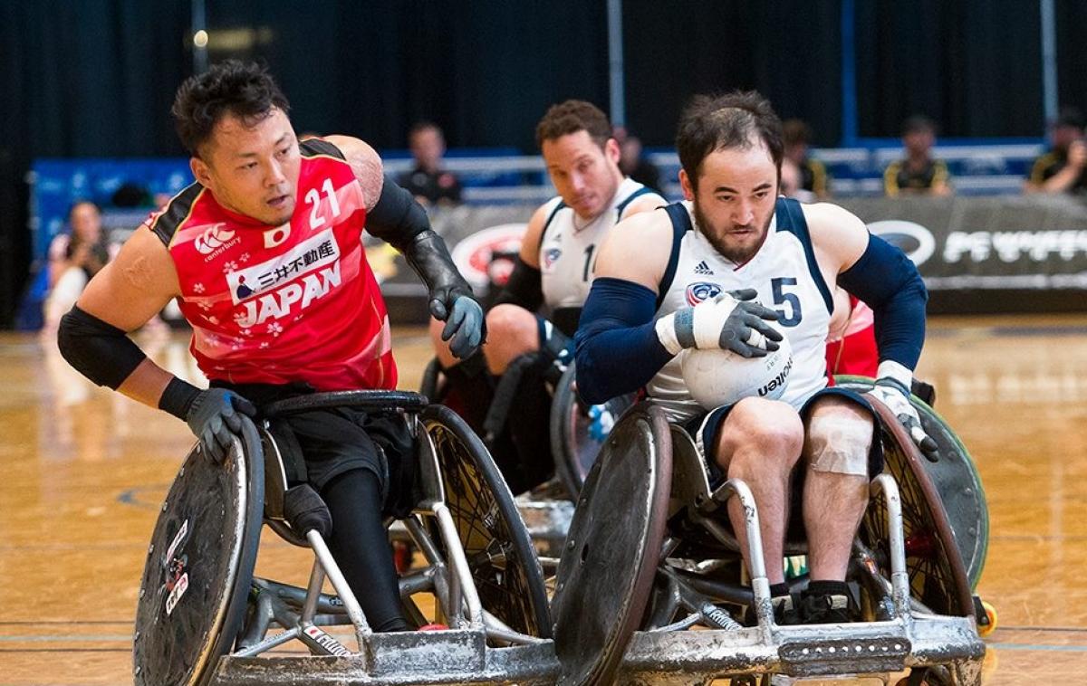 two male wheelchair rugby players clash on the court