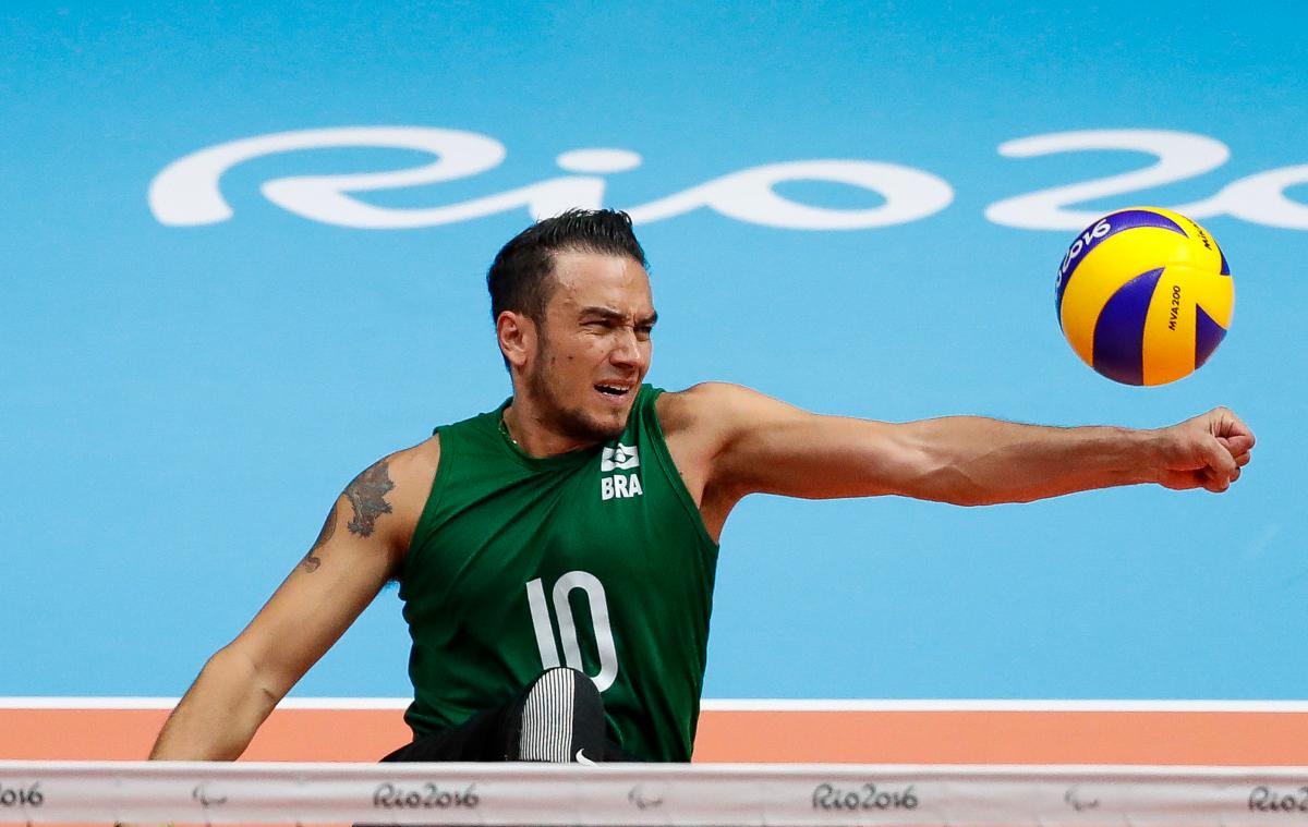 a male sitting volleyball player spikes the ball