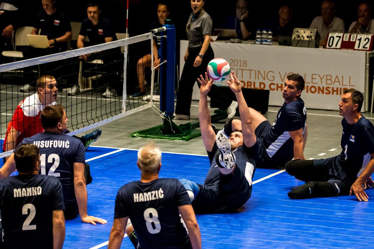 Bosnia beat Poland - men's sitting volleyball Worlds a group of Bosnian male sitting volleyball players working to get the ball back over the net
