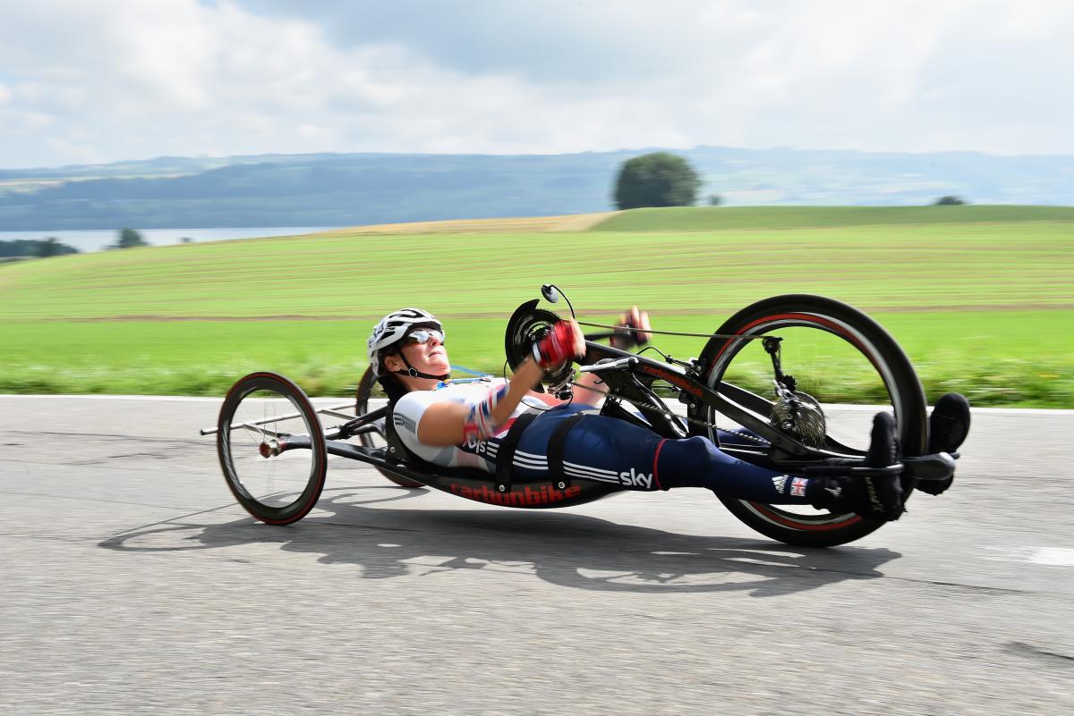 female British Para cyclist Karen Darke racing with a hand-bike on a road