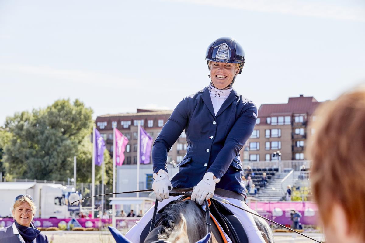 Dutch female rider smiles on her horse