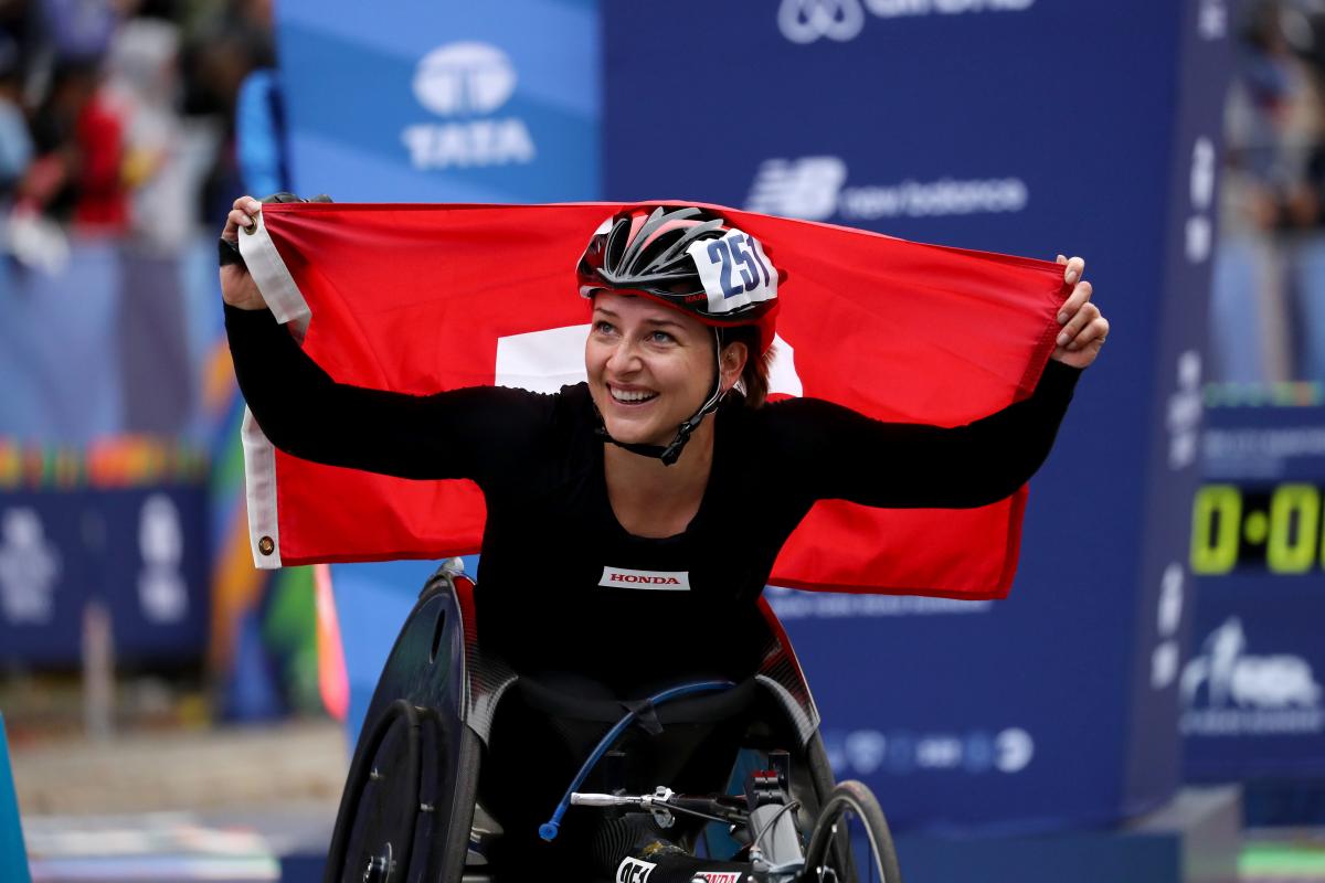 female wheelchair racer Manuela Schaer holds up the Swiss flag