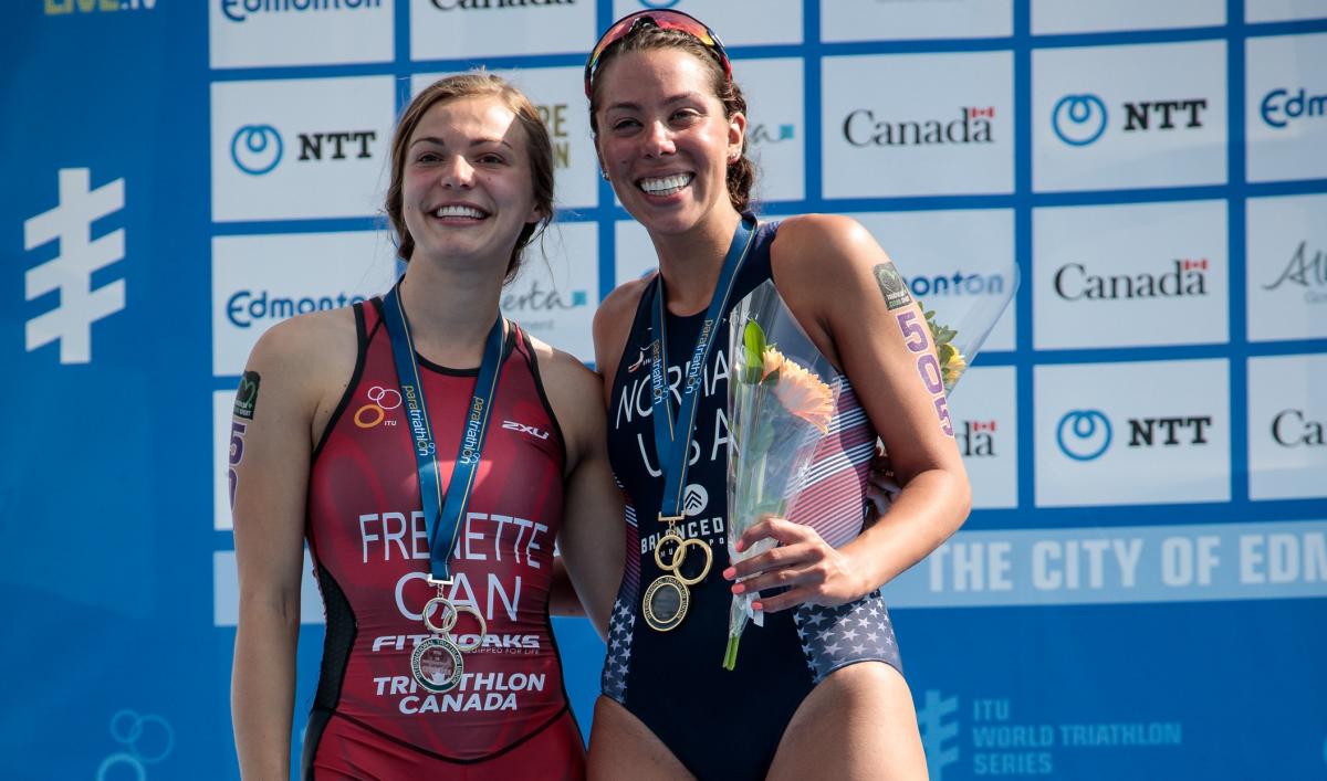 two female Para triathletes including Kamylle Frenette hugging on the podium