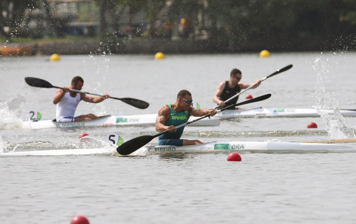 male Para canoeist Caio Carvalho mid-stroke during a race on the water