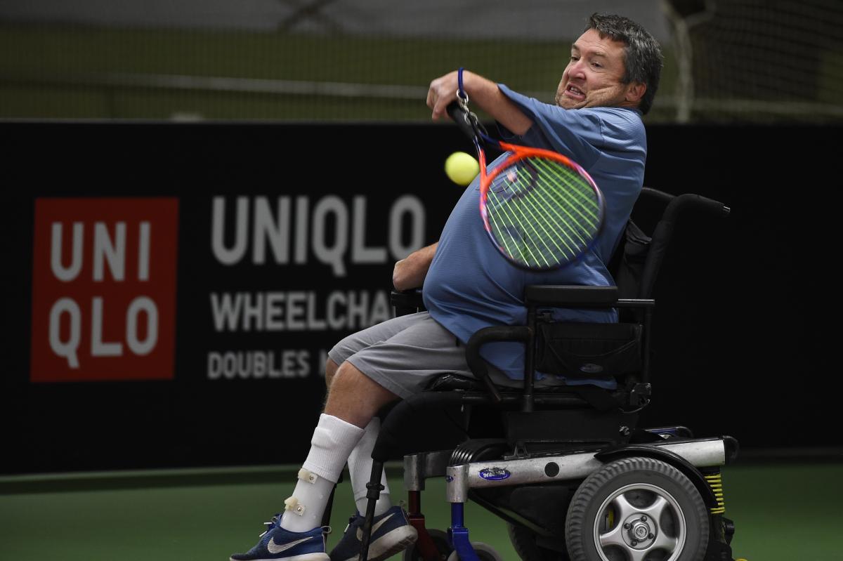 male wheelchair tennis player Nick Taylor plays a forehand on a hard court