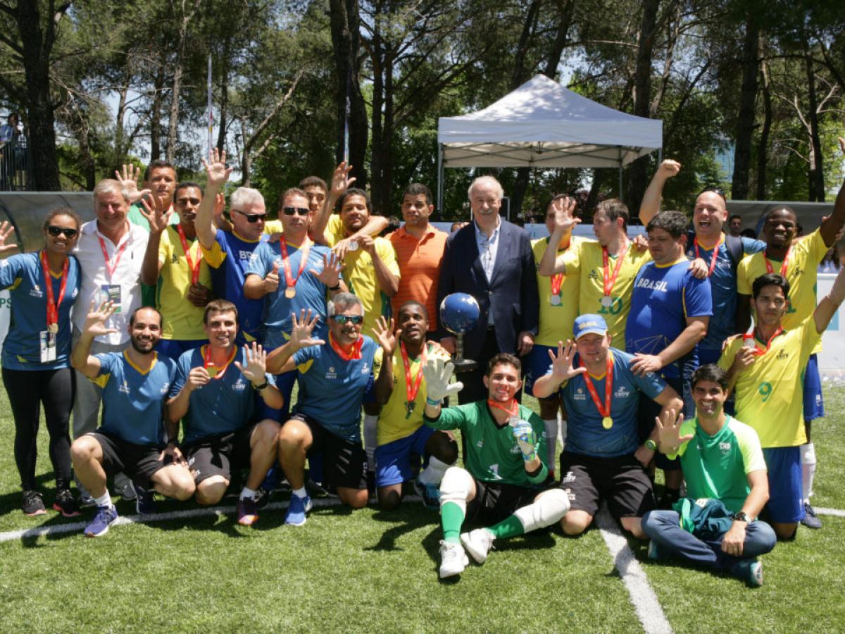 a group of male blind footballers wearing Brazil shirts and holding their hands up in celebration