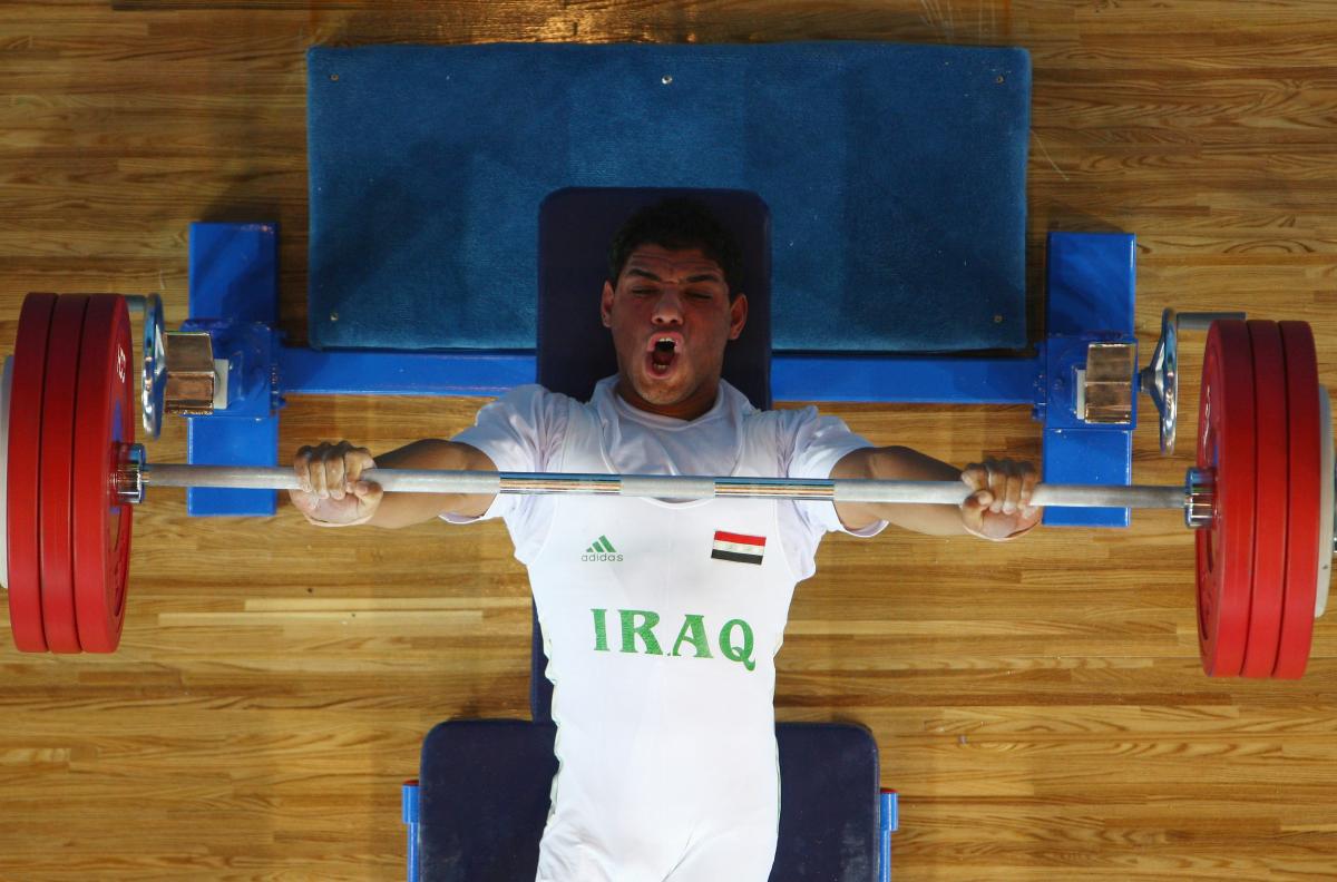 male powerlifter Rasool Mohsin yells as he lifts the bar