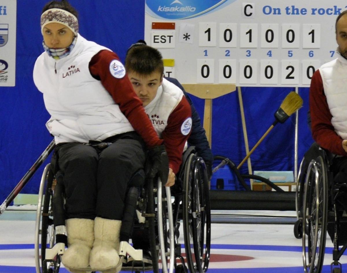 female wheelchair curler Polina Rozkova plays a stone