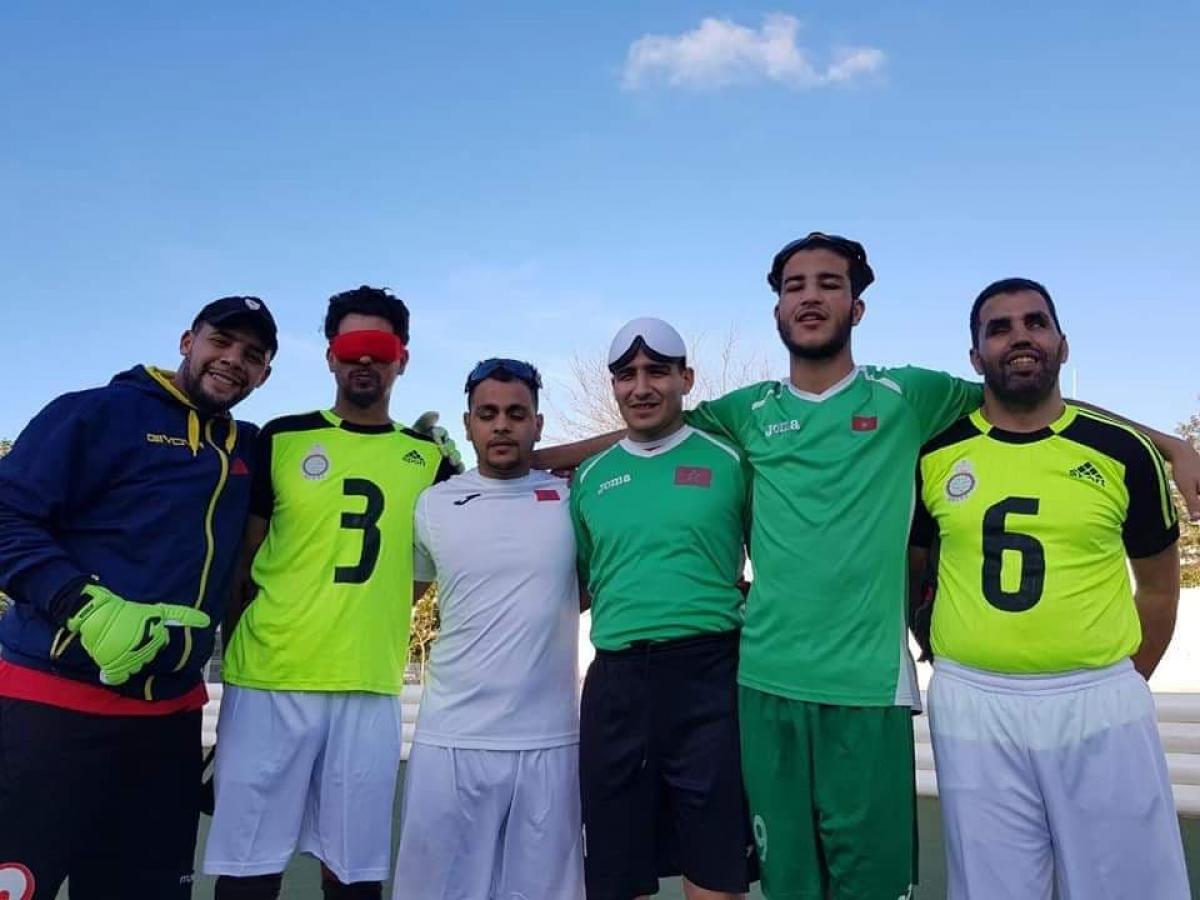 a group of five blind footballers from Oman smiling down at the camera