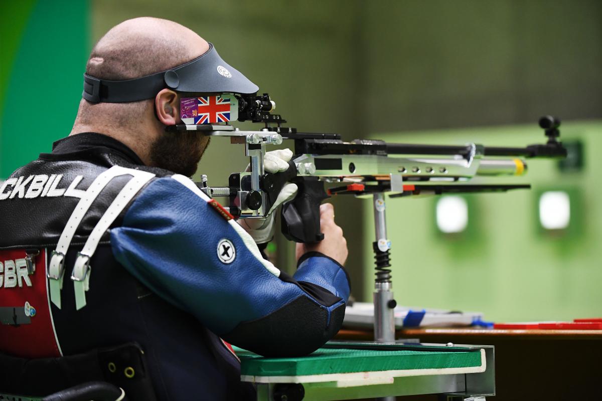 male Para shooter Ryan Cockbill prepares to shoot a rifle