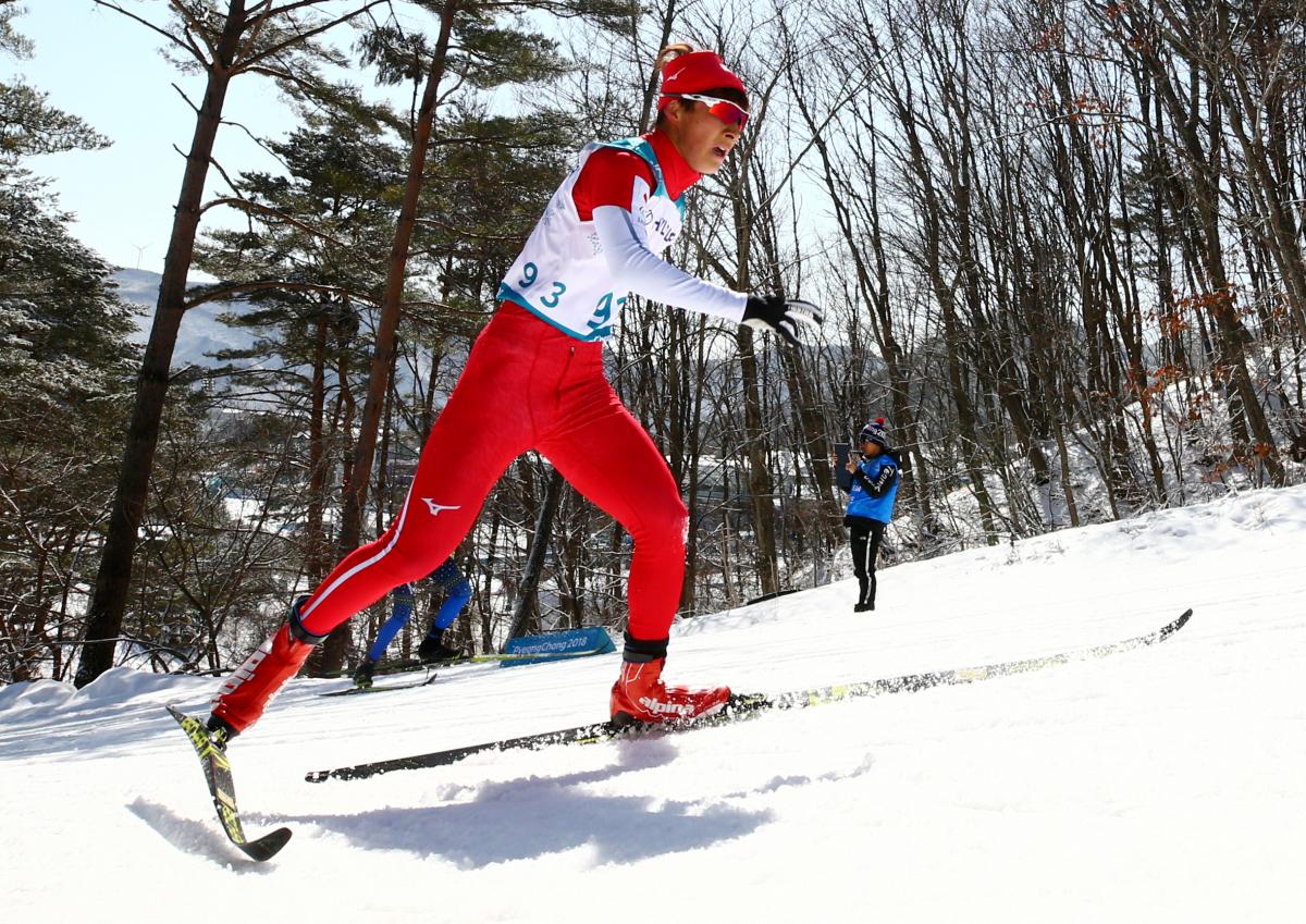 male Para Nordic skier Taiki Kawayoke skis through the forest