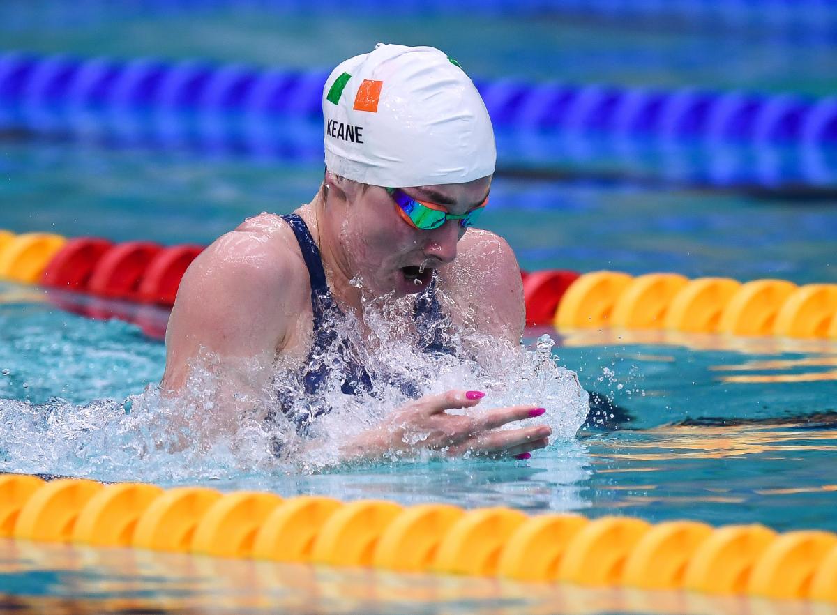 A female swimmer with a cap showing the flag of Ireland