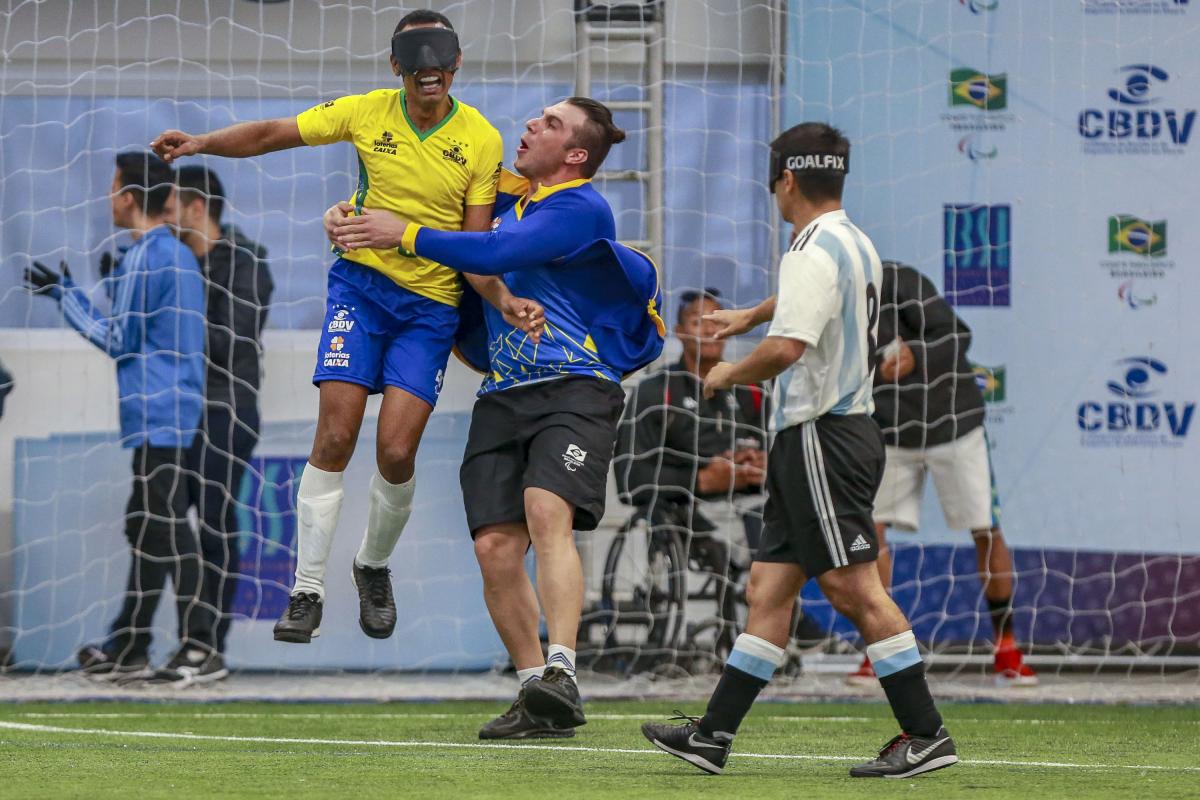 Raimundo Nonato jumps and celebrates his goal while Argentinian defender express sadness