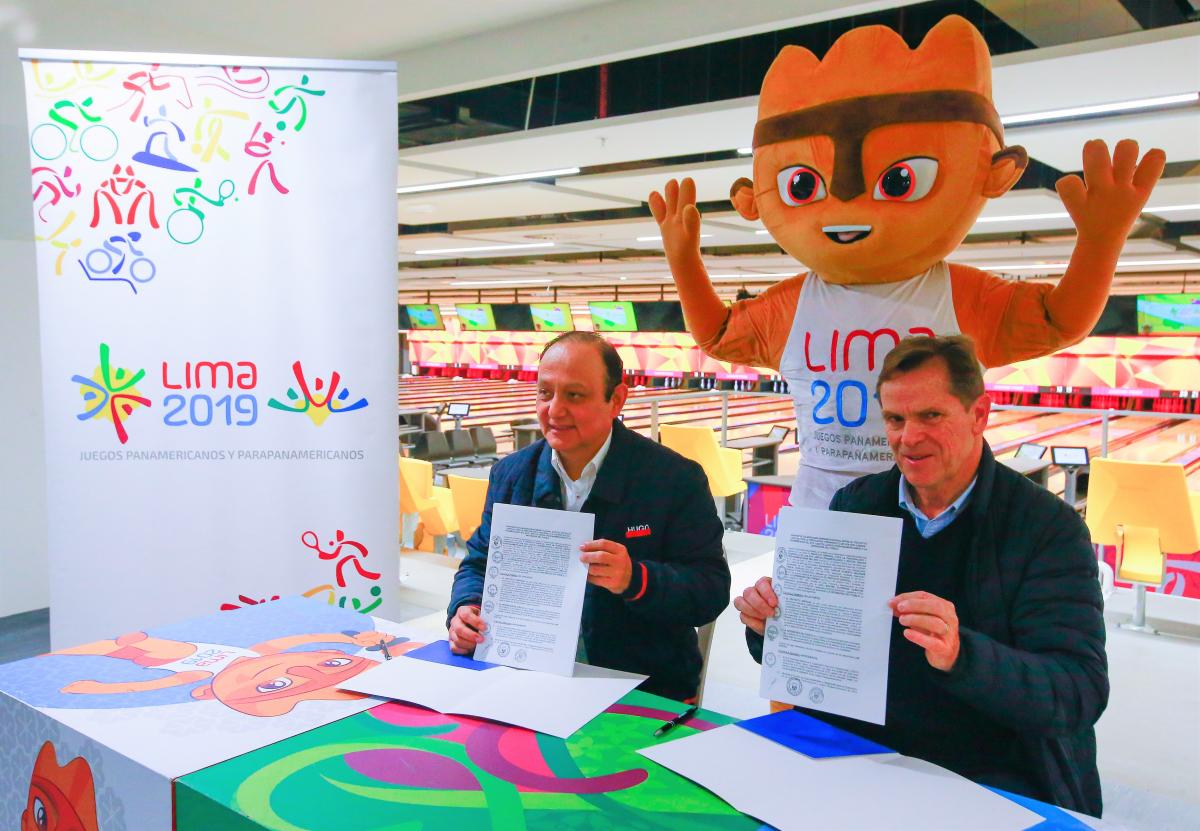 Lima 2019 President Carlos Neuhaus and Peruvian Ombudsman Walter Gutierrez holding the signed contracts